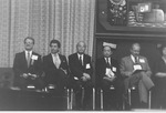 5 men seated on stage